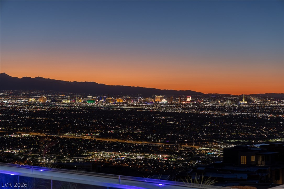 563 Grand Rim Drive Henderson, NV 89012 - Photo 51 of 70 City lights dazzle against the evening sky, framed by distant mountains and a vibrant sunset.