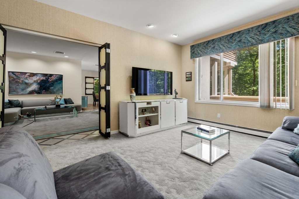 228 Allandale Road, Unit 1B Boston, MA 02467 - Photo 19 of 30 a living room with furniture a flat screen tv and a fireplace