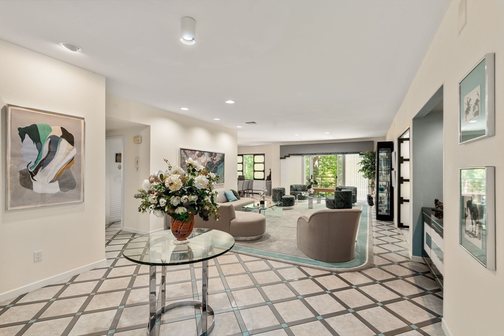 228 Allandale Road, Unit 1B Boston, MA 02467 - Photo 2 of 30 a living room with furniture a chandelier and a dining table