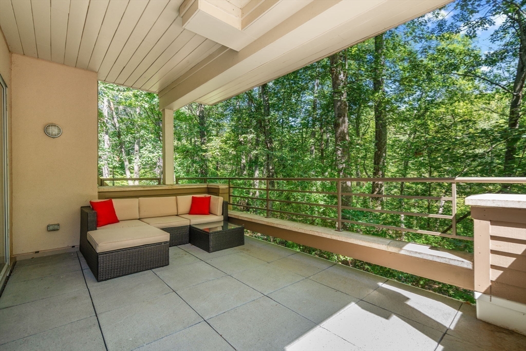 228 Allandale Road, Unit 1B Boston, MA 02467 - Photo 23 of 30 a living room with patio furniture and a garden