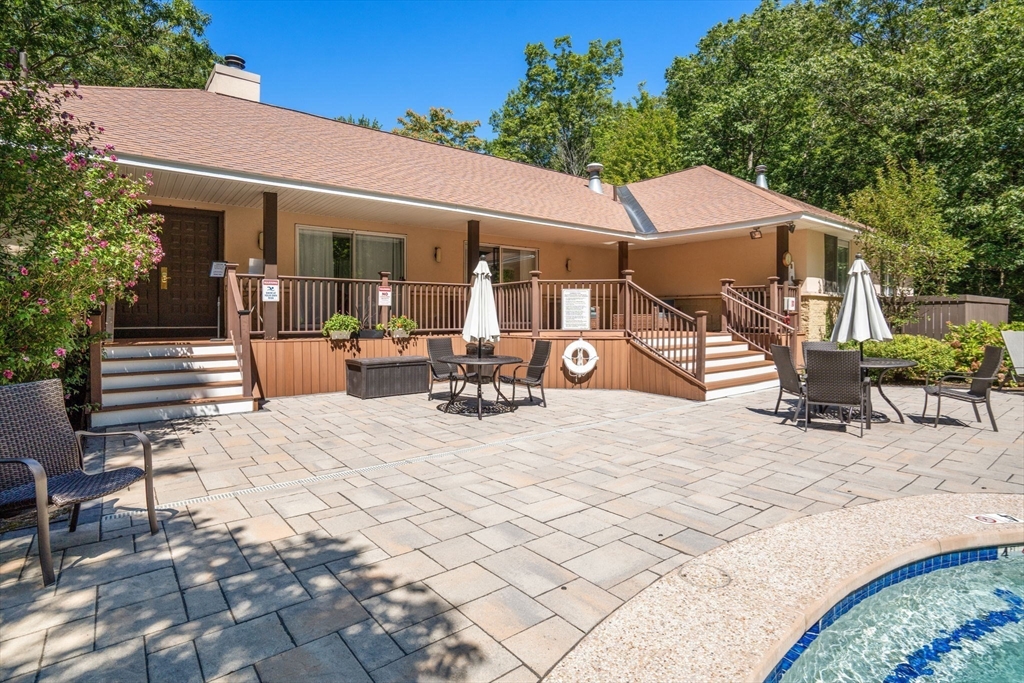 228 Allandale Road, Unit 1B Boston, MA 02467 - Photo 27 of 30 a patio with a table and chairs under an umbrella