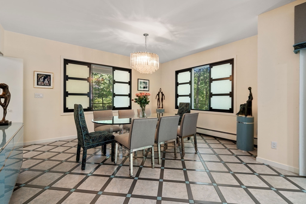 228 Allandale Road, Unit 1B Boston, MA 02467 - Photo 7 of 30 a view of a dining room with furniture a chandelier and wooden floor