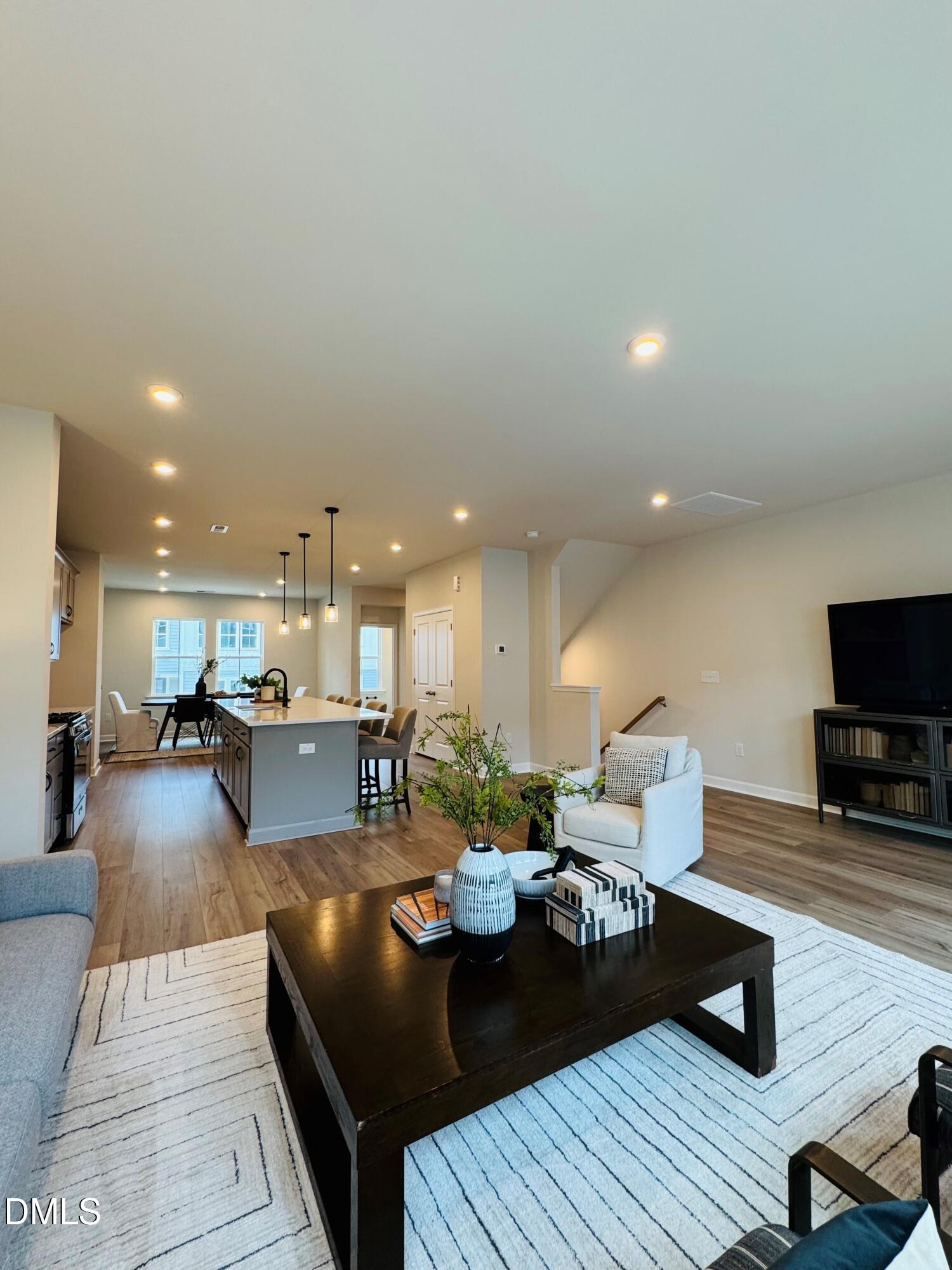 706 Hyperion Alley Wake Forest, NC 27587 - Photo 11 of 65 a living room with furniture a flat screen tv and kitchen view