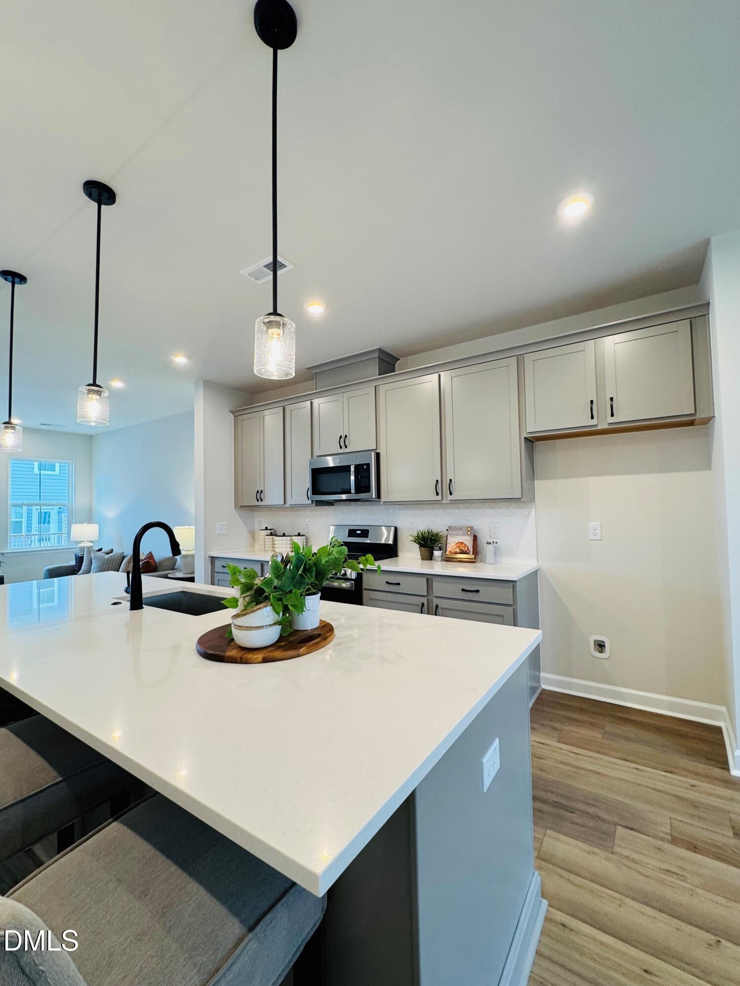 706 Hyperion Alley Wake Forest, NC 27587 - Photo 7 of 67 a kitchen with a sink a refrigerator and cabinets