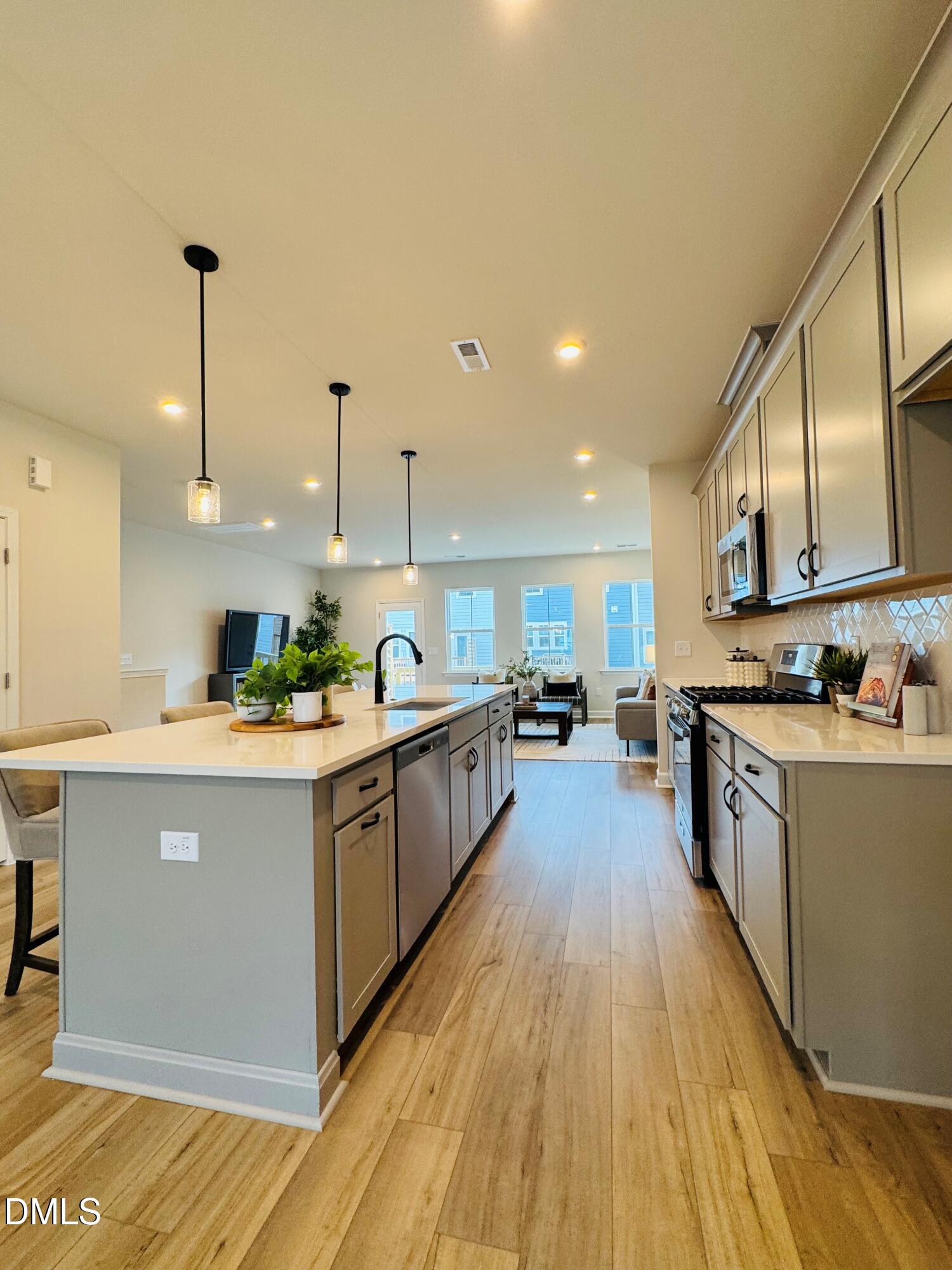 706 Hyperion Alley Wake Forest, NC 27587 - Photo 10 of 67 a large kitchen with stainless steel appliances granite countertop a large counter top a stove a sink and a refrigerator
