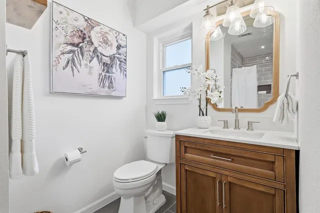 a bathroom with a sink vanity and a toilet