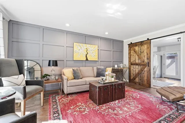 a living room with furniture a rug and white walls