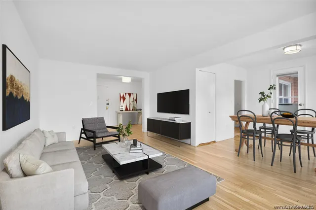 a living room with furniture a flat screen tv and a table