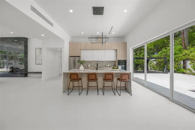 a kitchen with kitchen island a large window a sink and a refrigerator