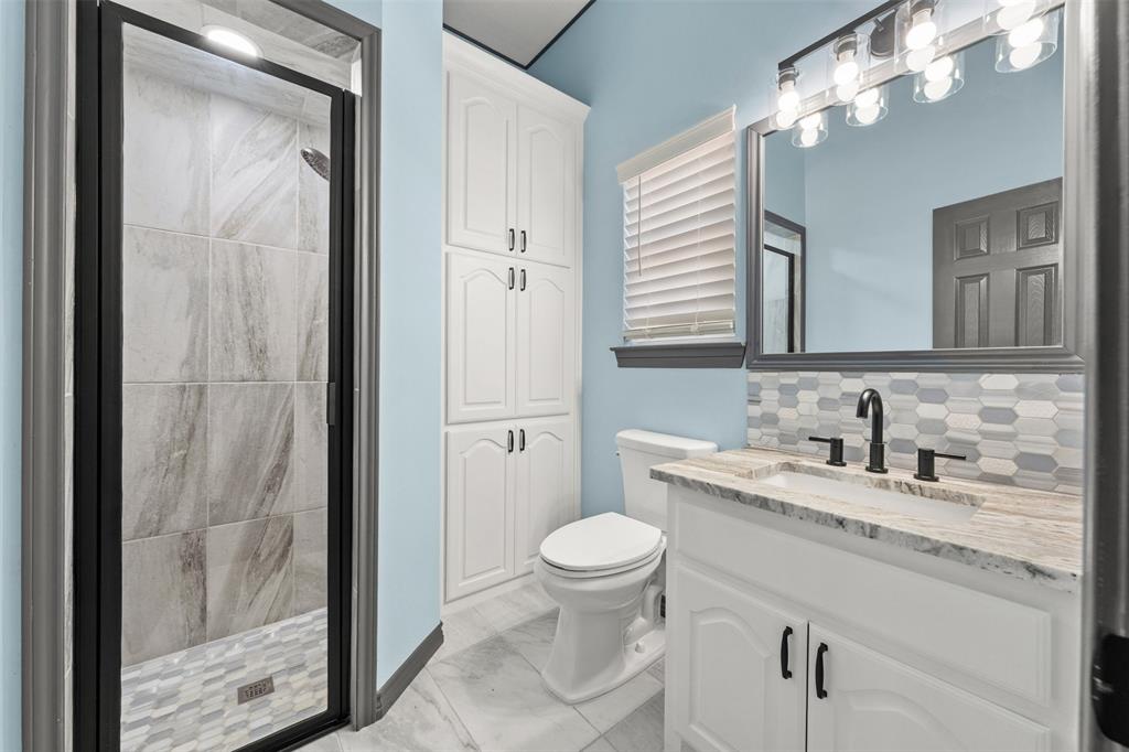 3091 Rockbridge Road McGregor, TX 76657 - Photo 14 of 40 a bathroom with a granite countertop sink a toilet and a mirror