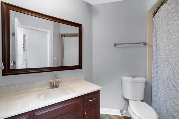a bathroom with a toilet a sink and mirror