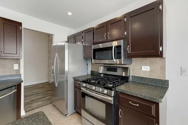 a kitchen with stainless steel appliances granite countertop a stove and a refrigerator