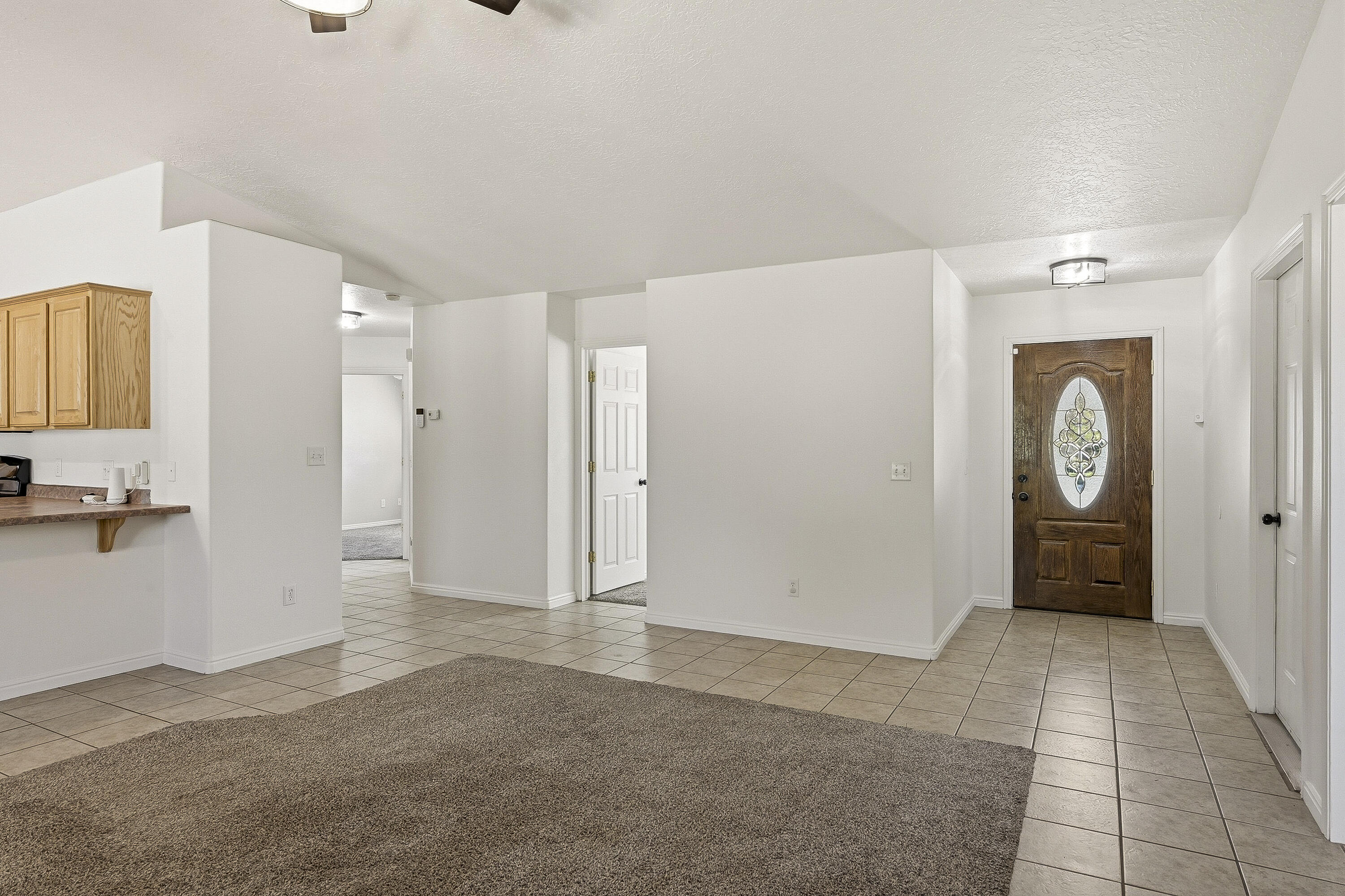 4510 North Half Mile Road Cedar City, UT 84721 - Photo 8 of 48 Tile flooring extends through the kitchen, dining area, hallways, and bathrooms, providing durability and easy maintenance.