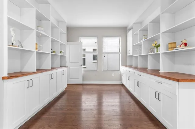 a large white kitchen with cabinets and wooden floor