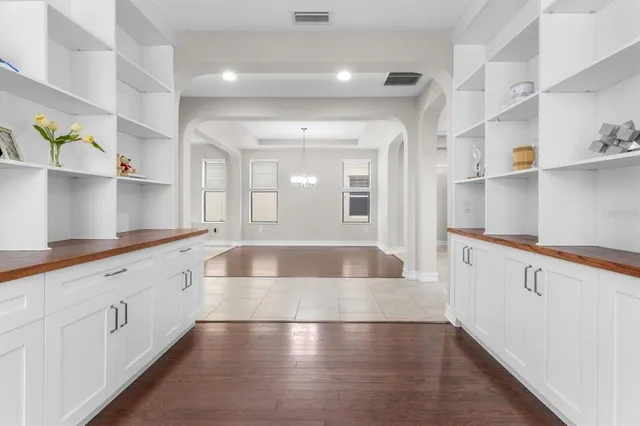 a large white kitchen with lots of counter space and wooden floor