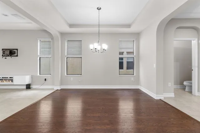 a view of an empty room with window and wooden floor
