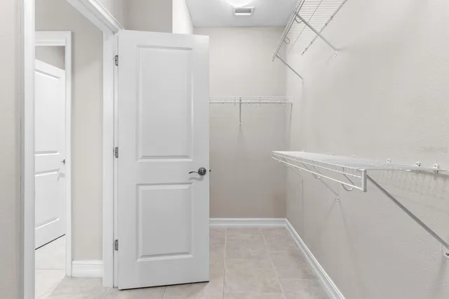 a view of walk in closet with empty racks