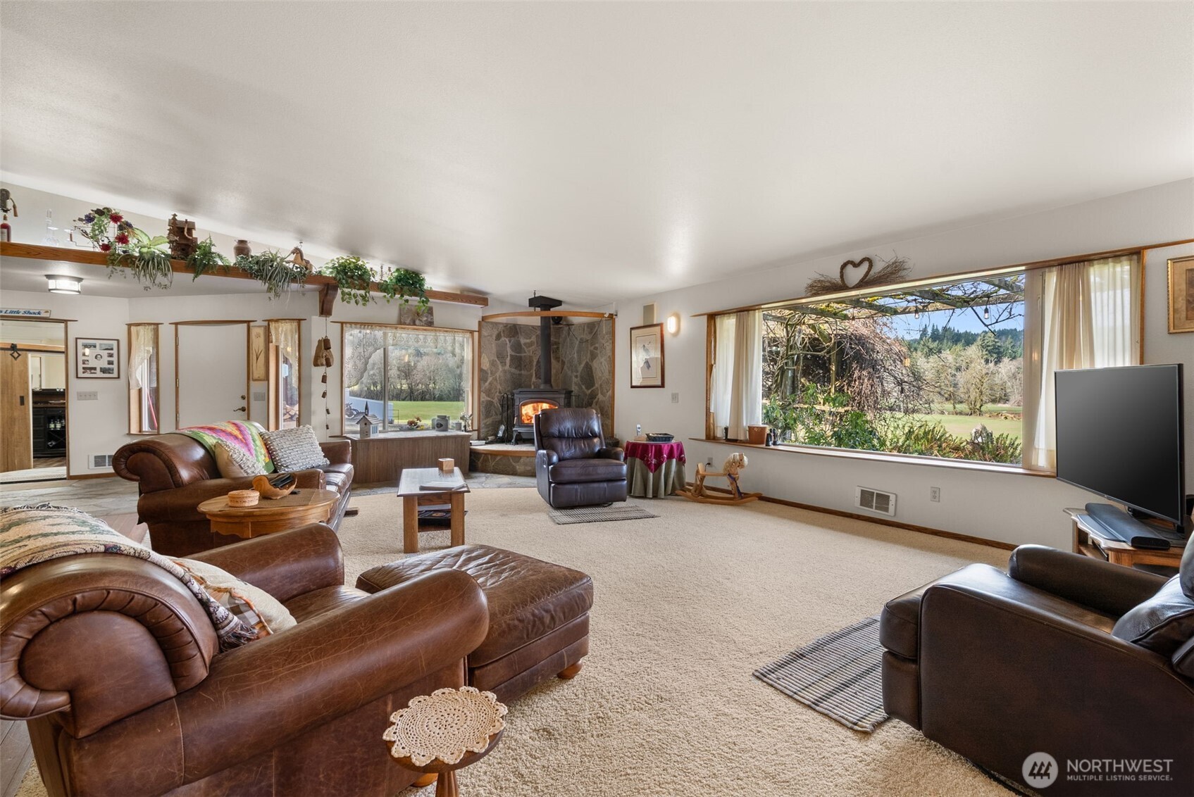 65 Wilderness Road Oakville, WA 98568 - Photo 7 of 40 a living room with furniture a floor to ceiling window and a flat screen tv