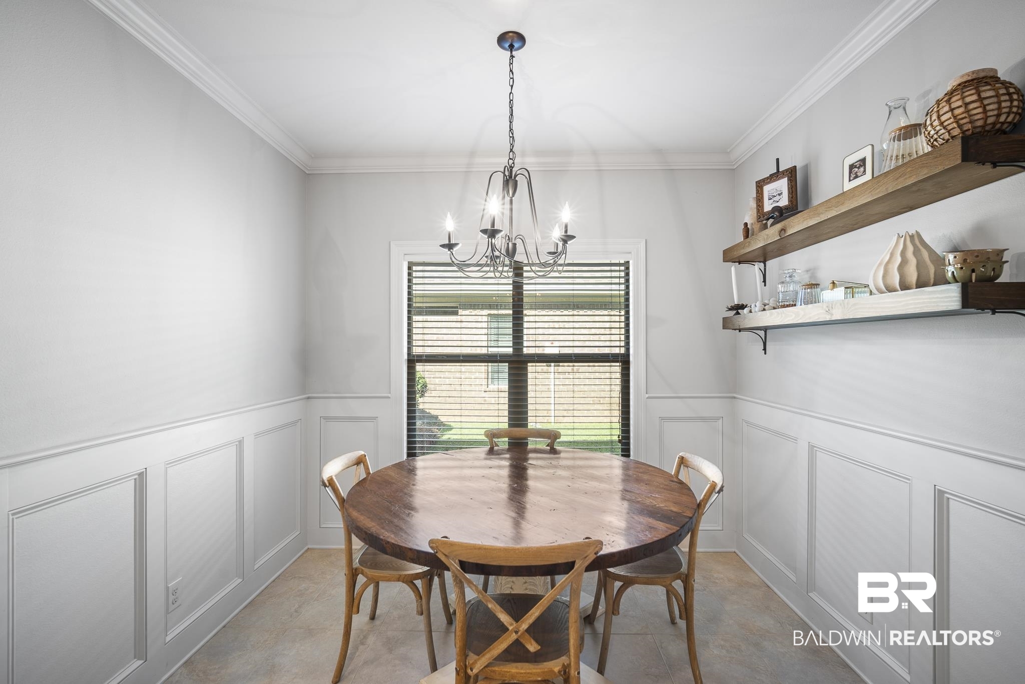 8594 Rosedown Lane Daphne, AL 36526 - Photo 9 of 30 Dining space featuring a nice light fixture, crown molding, and wainscoting