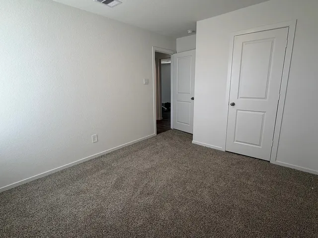 an empty room with wooden floor and white wall