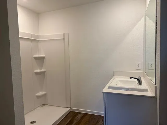 a bathroom with a sink a toilet and shower