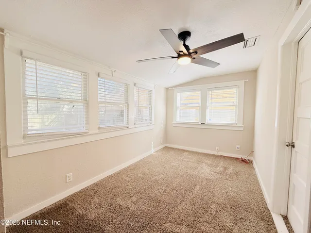 a view of a room with a ceiling fan and a window