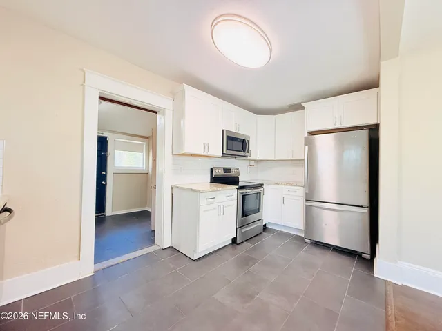 a kitchen with stainless steel appliances granite countertop a sink a stove a microwave and wooden cabinets