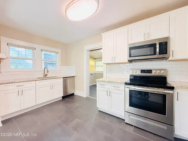 a kitchen with granite countertop a sink and cabinets