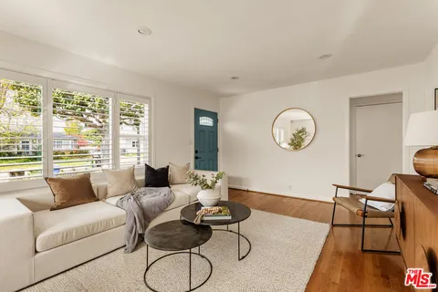 a living room with furniture a table and a large window