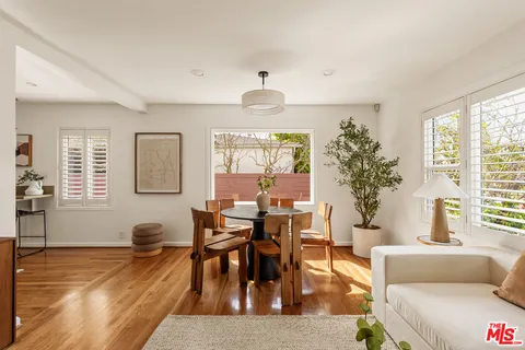 a living room with furniture a window and a potted plant