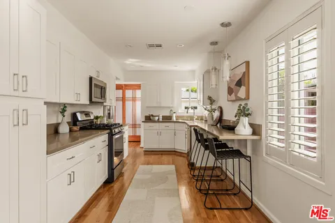 a kitchen with white cabinets and appliances