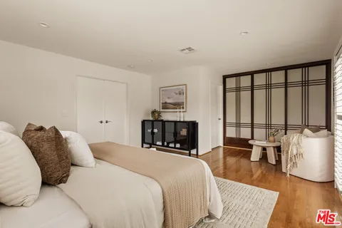 a bedroom with a bed and glass walk in closet