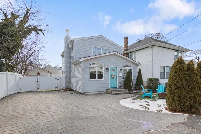 a view of a house with a yard and large tree