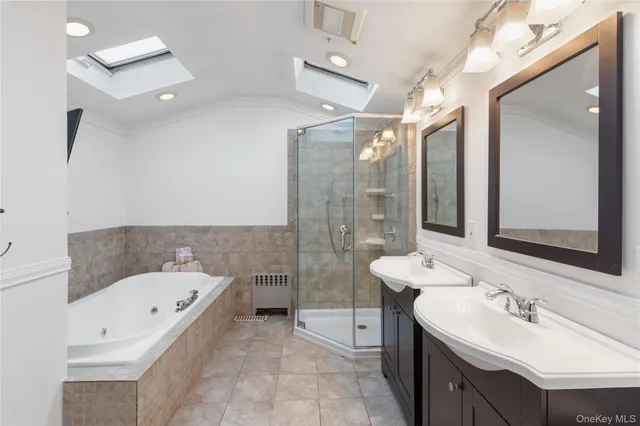 a bathroom with a bathtub shower sink mirror and toilet
