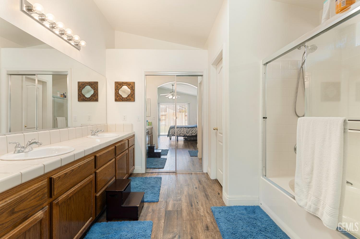 Undisclosed Address Bakersfield, CA 93311 - Photo 11 of 17 a spacious bathroom with a shower a sink and a mirror
