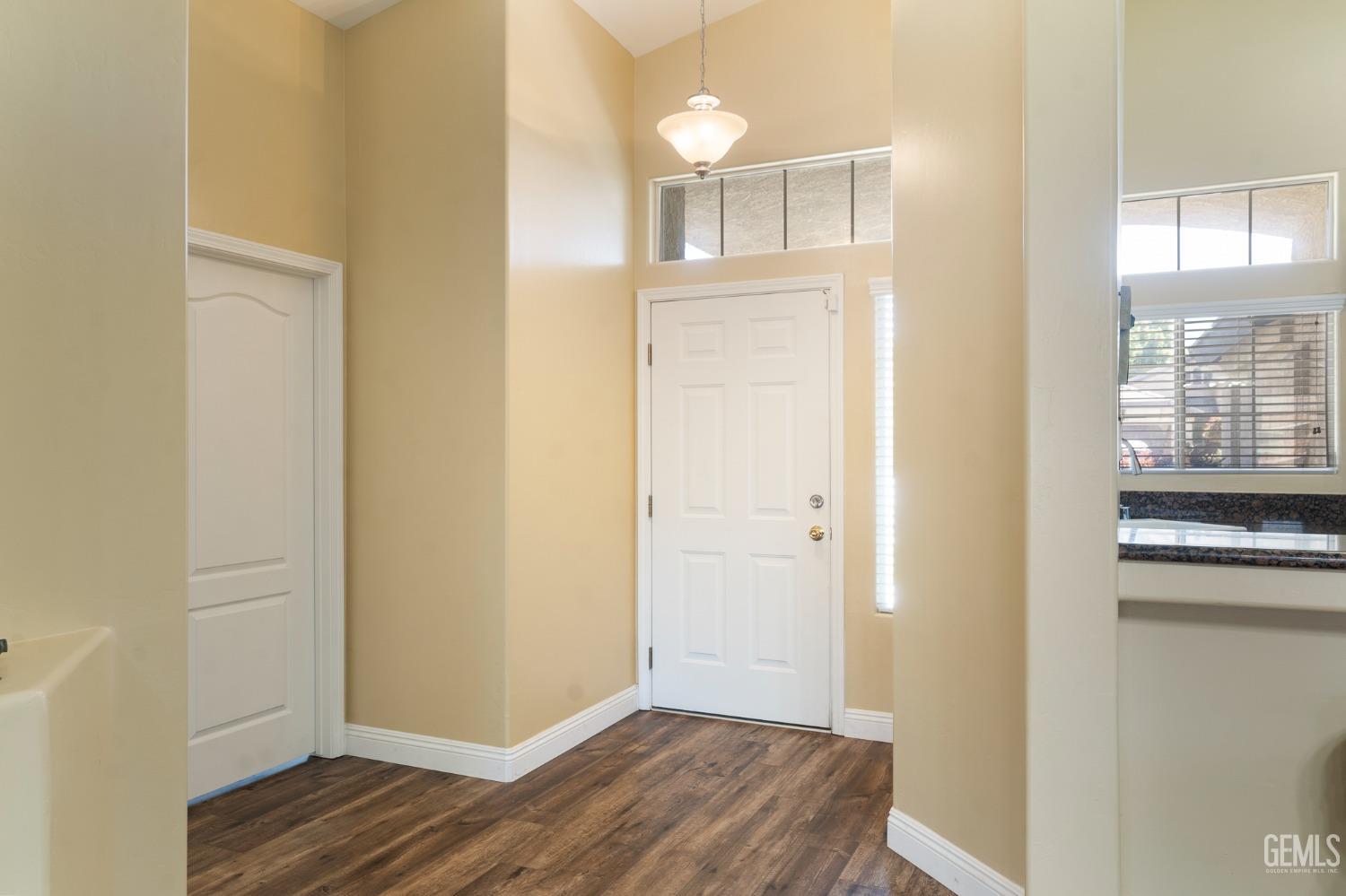 Undisclosed Address Bakersfield, CA 93311 - Photo 3 of 17 a view of a hallway with wooden floor and a bathroom