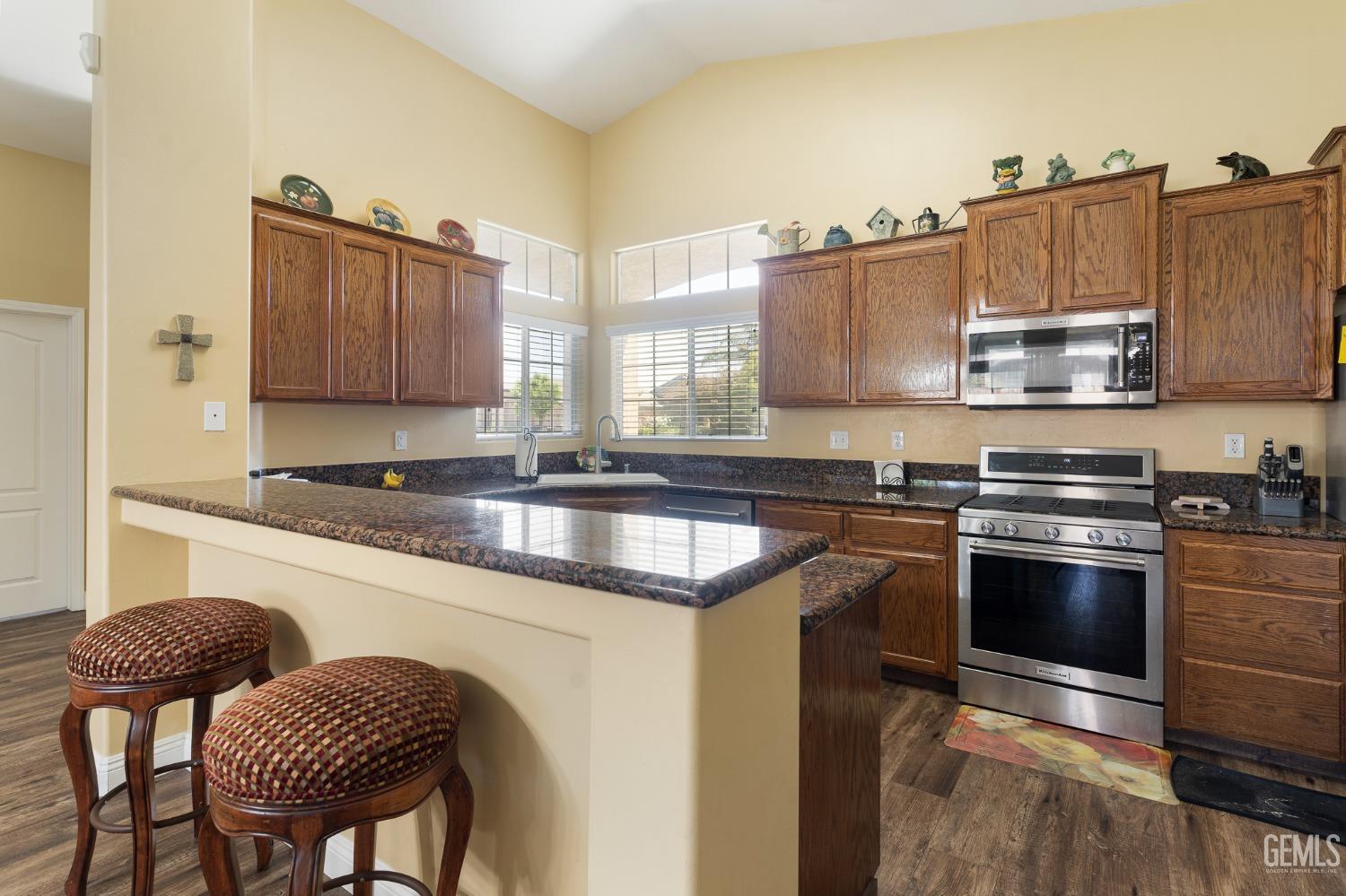 Undisclosed Address Bakersfield, CA 93311 - Photo 7 of 17 a kitchen with granite countertop a stove a sink and a microwave