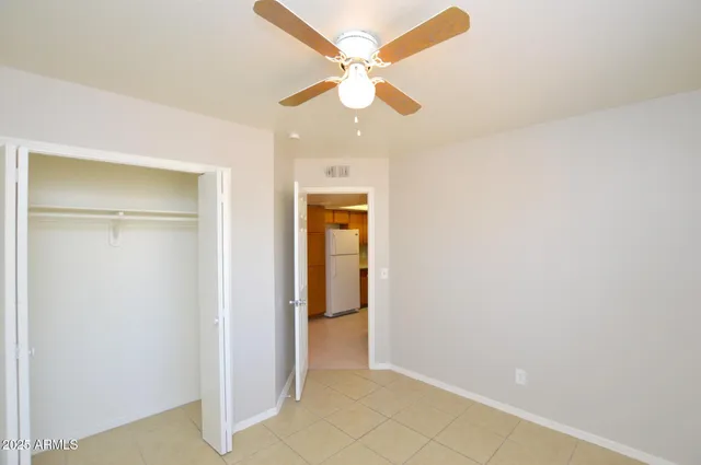a view of an empty room with a ceiling fan and a window