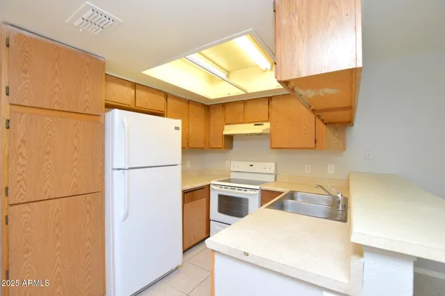a kitchen with a sink a refrigerator and a stove