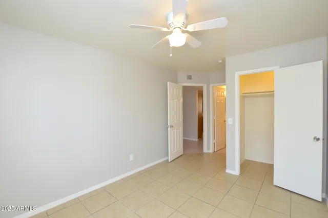 an empty room with a ceiling fan and a bathroom