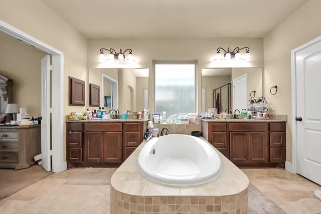 a large white kitchen with a sink and chandelier