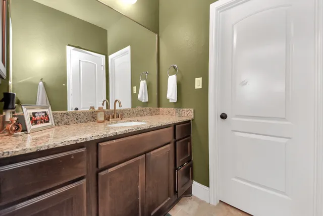 a bathroom with a granite countertop sink and a mirror