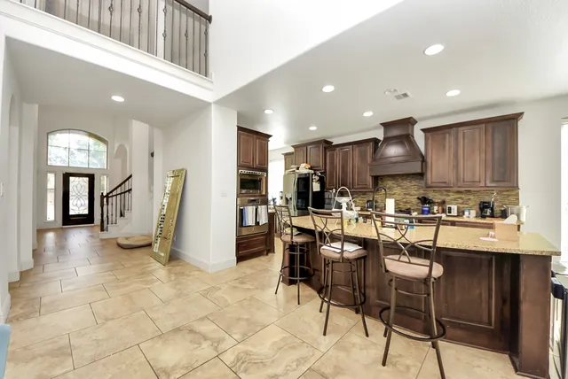 a view of kitchen with refrigerator and chairs