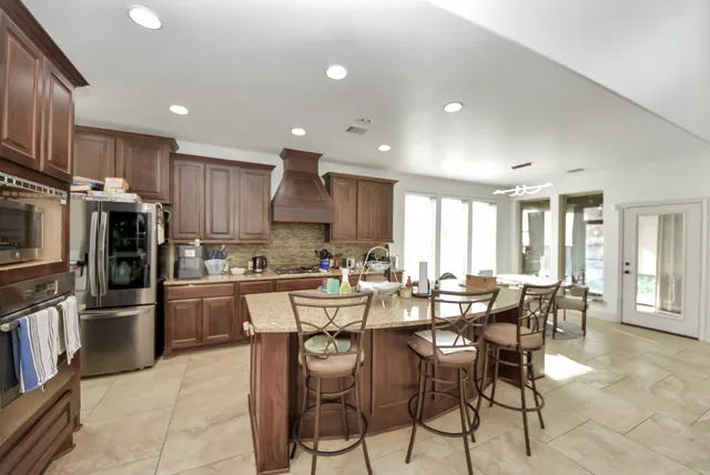 a large kitchen with lots of counter space dining table and stainless steel appliances