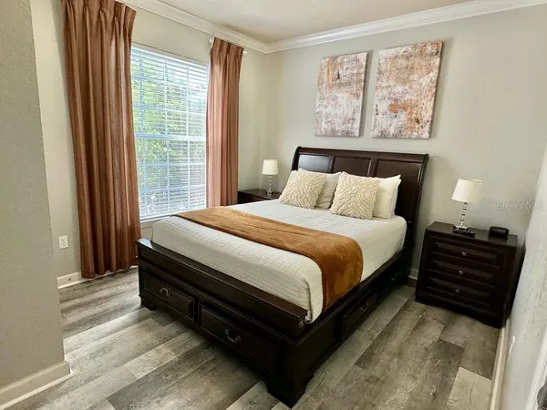 a bedroom with a bed and a large window