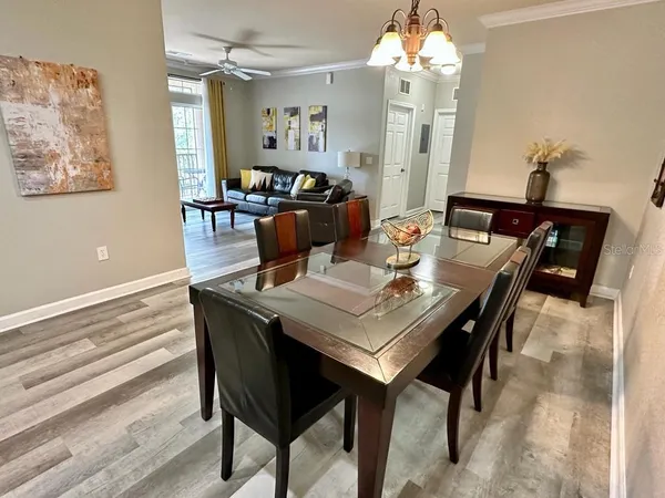 a view of a dining room with furniture a chandelier and wooden floor