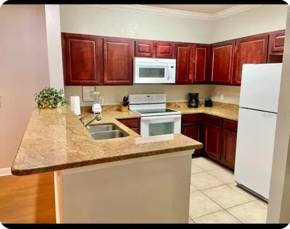 a kitchen with stainless steel appliances granite countertop a refrigerator sink stove and microwave
