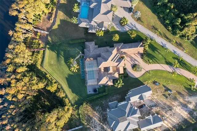 an aerial view of a house with a yard and large trees