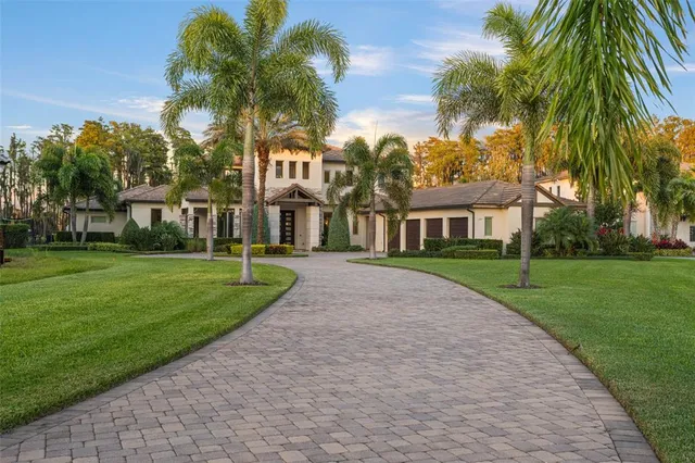 front view of house with a yard and palm trees