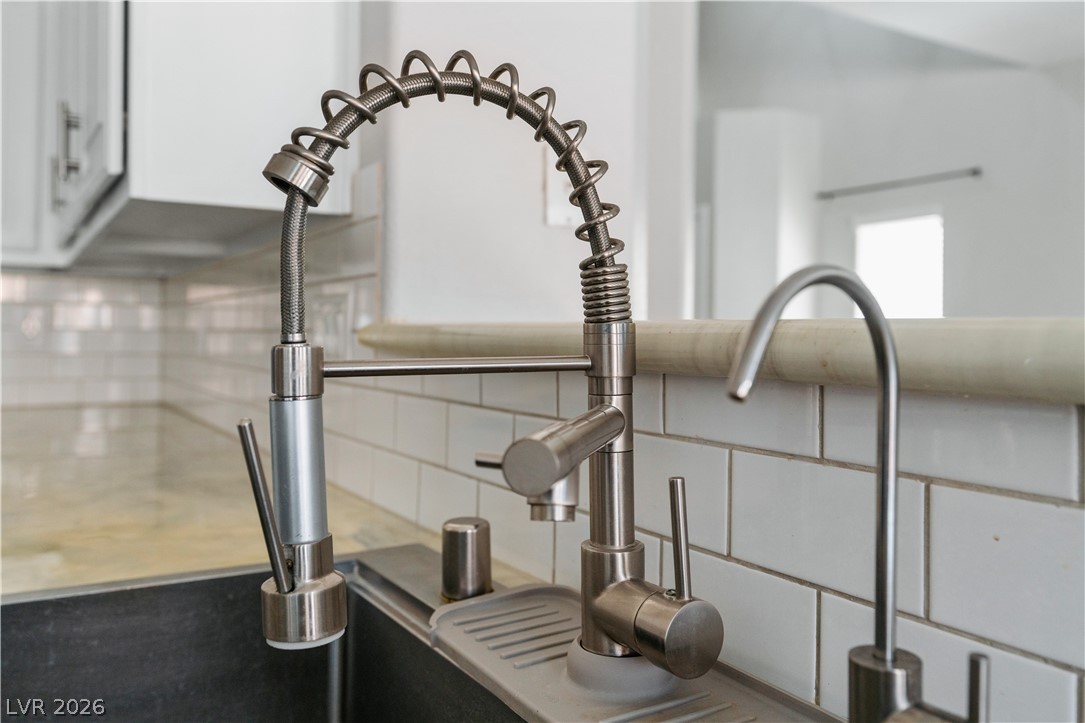 1328 Spice Ridge Court Henderson, NV 89012 - Photo 14 of 51 This contemporary kitchen features a sleek faucet with a spring spout and an additional water filter tap.